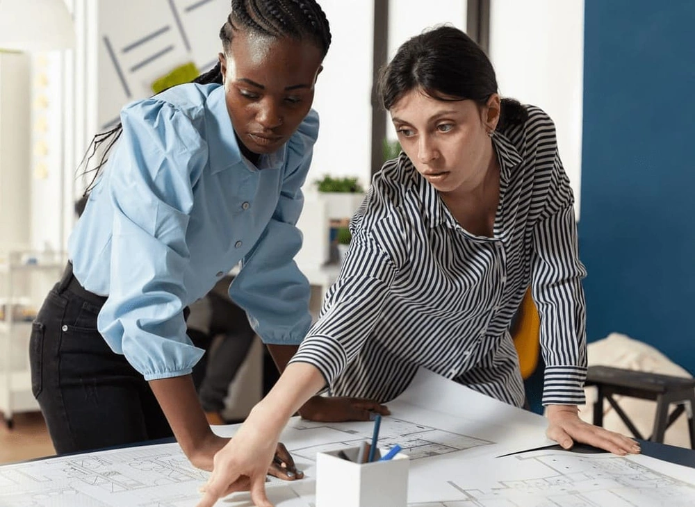 Two AEC professionals comparing the printouts from various types of plotters Two AEC professionals comparing the printouts from various types of plotters