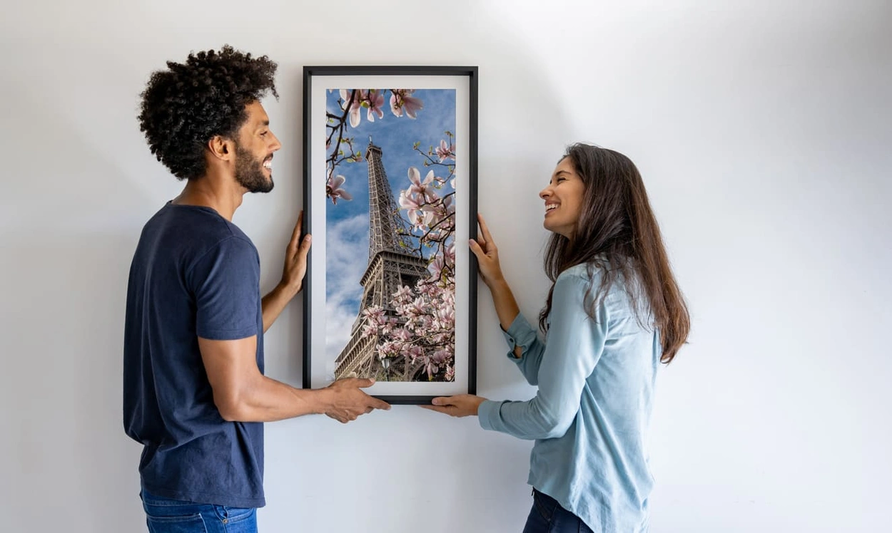 Couple hanging a high-quality photo art print like those possible with the best large format printers for artists from HP