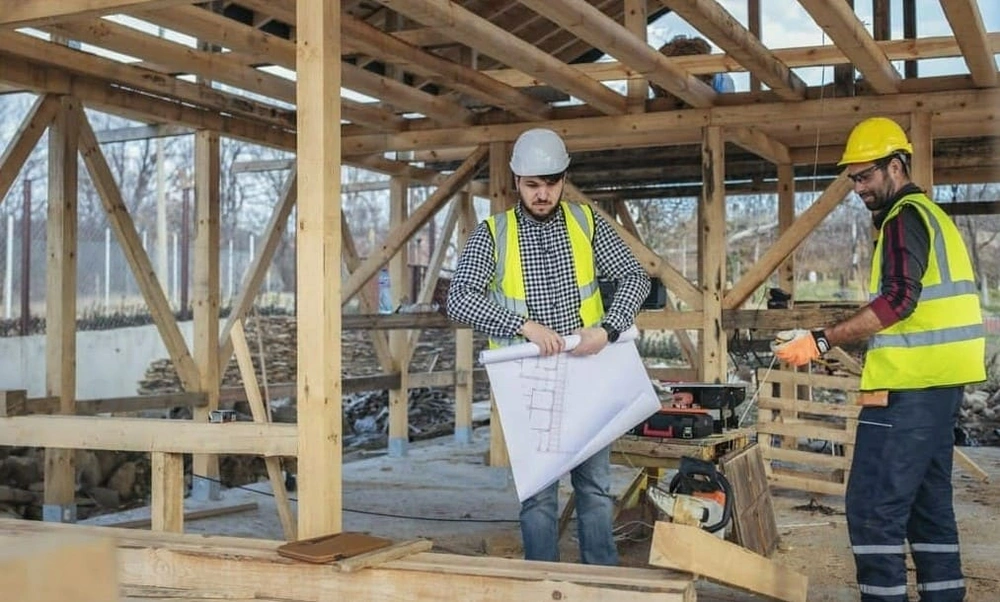 Construction team reading architectural drawings at an active worksite