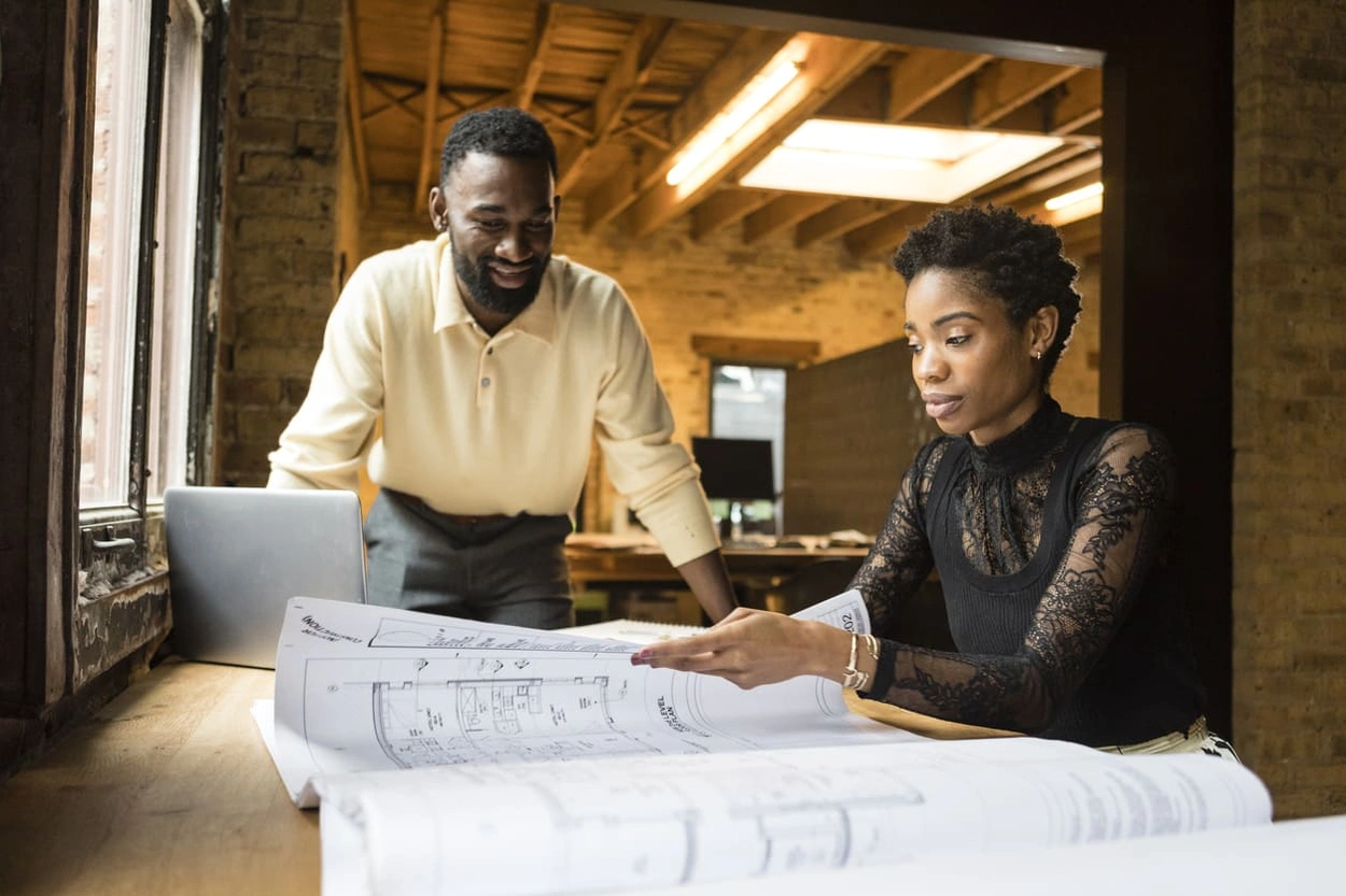 Coworkers refining their process for how to print and handle large format prints