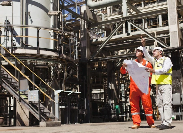 Construction technicians reading build details off different blueprint paper sizes