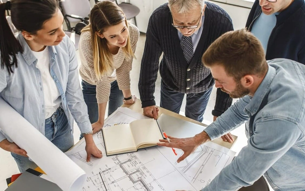 Group of architects looking at a blueprint drawing 