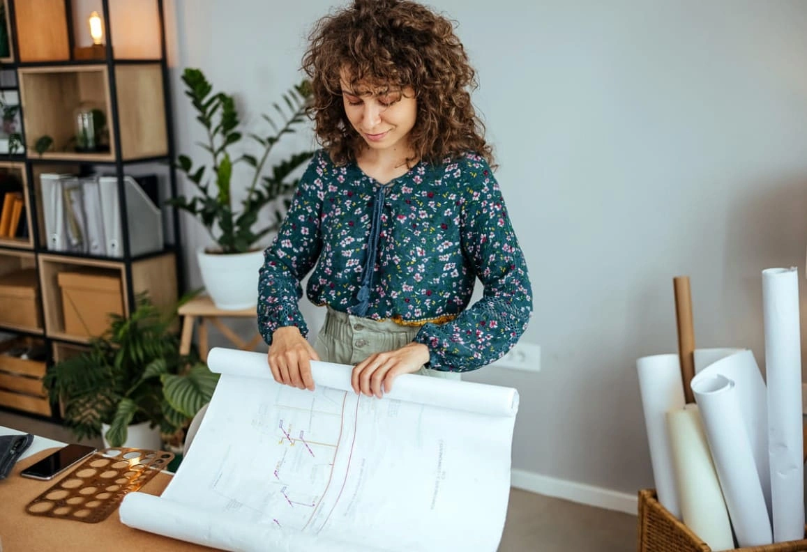 Architect making changes to a new plan printed on her office's printer and plotter Architect making changes to a new plan printed on her office's printer and plotter
