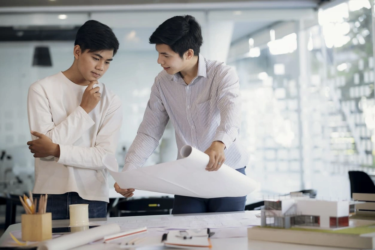 Architects reviewing printed blueprints as part of their hybrid AEC printing workflow