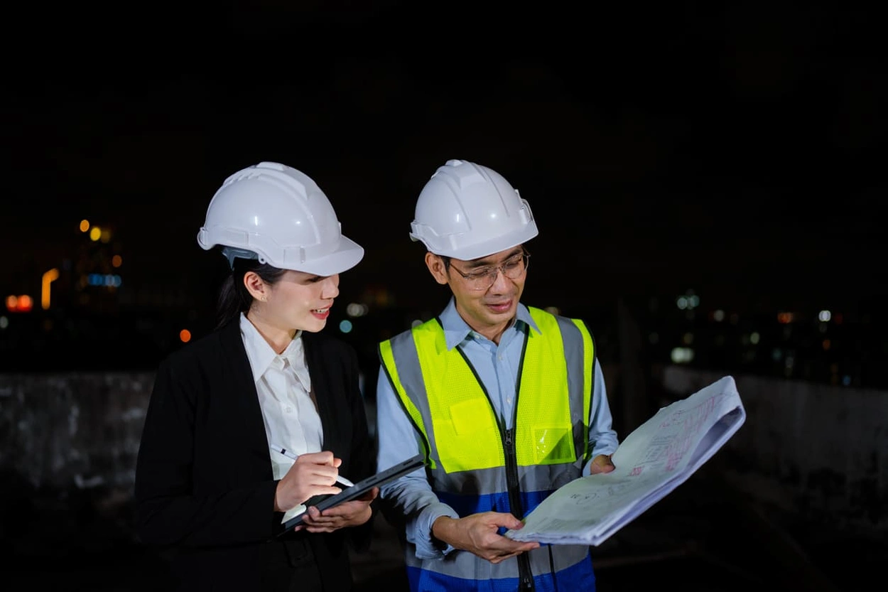 Two on-site professionals reviewing documents with the optimal image resolution for large format printing