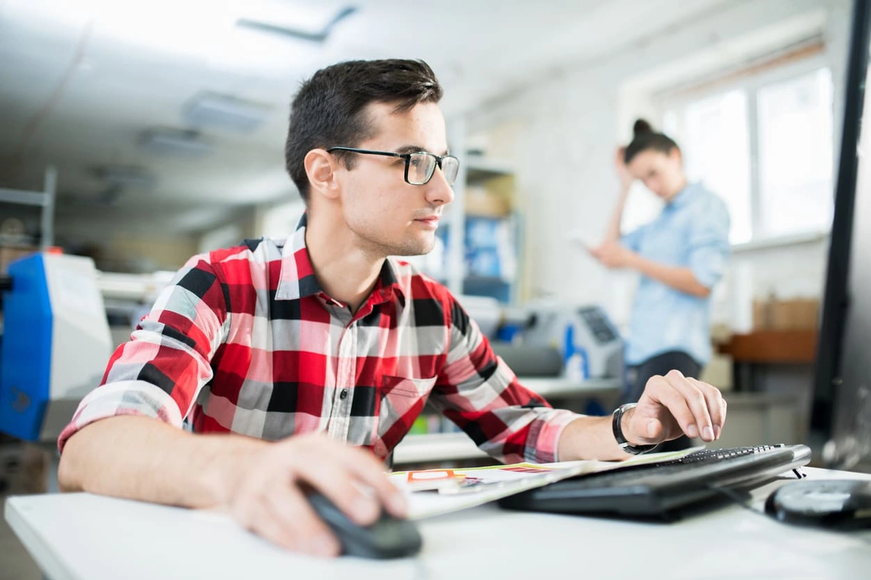 Printing press employee looking up 'what is an ICC profile in printing' to complete specialty projects