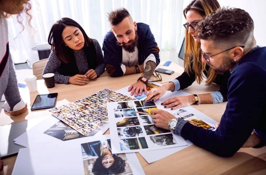 Advertising team assessing photos printed with the best printer for photo printing to plan a new campaign