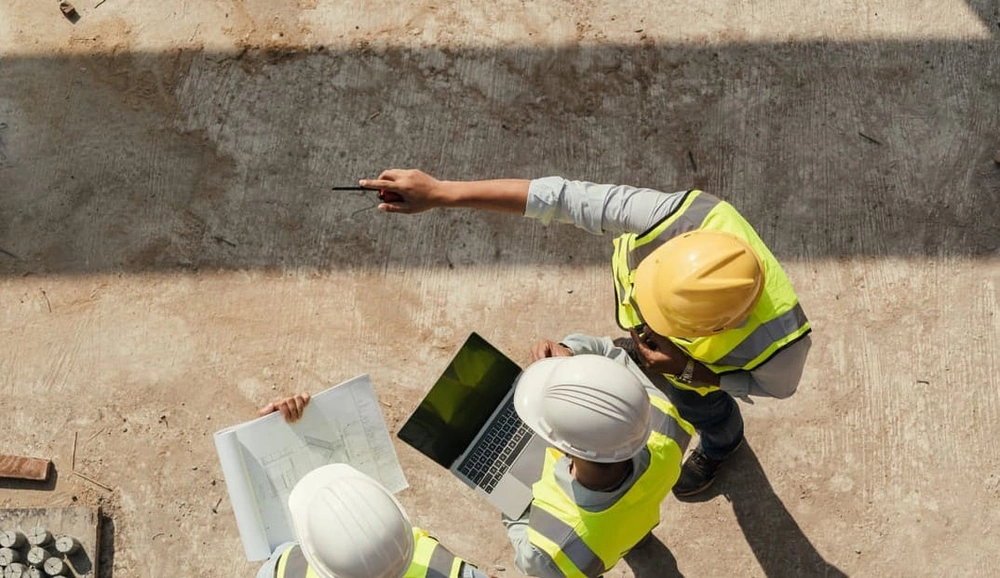 On-site team seeing advantages in digital architectural drawings and paper blueprints On-site team seeing advantages in digital architectural drawings and paper blueprints