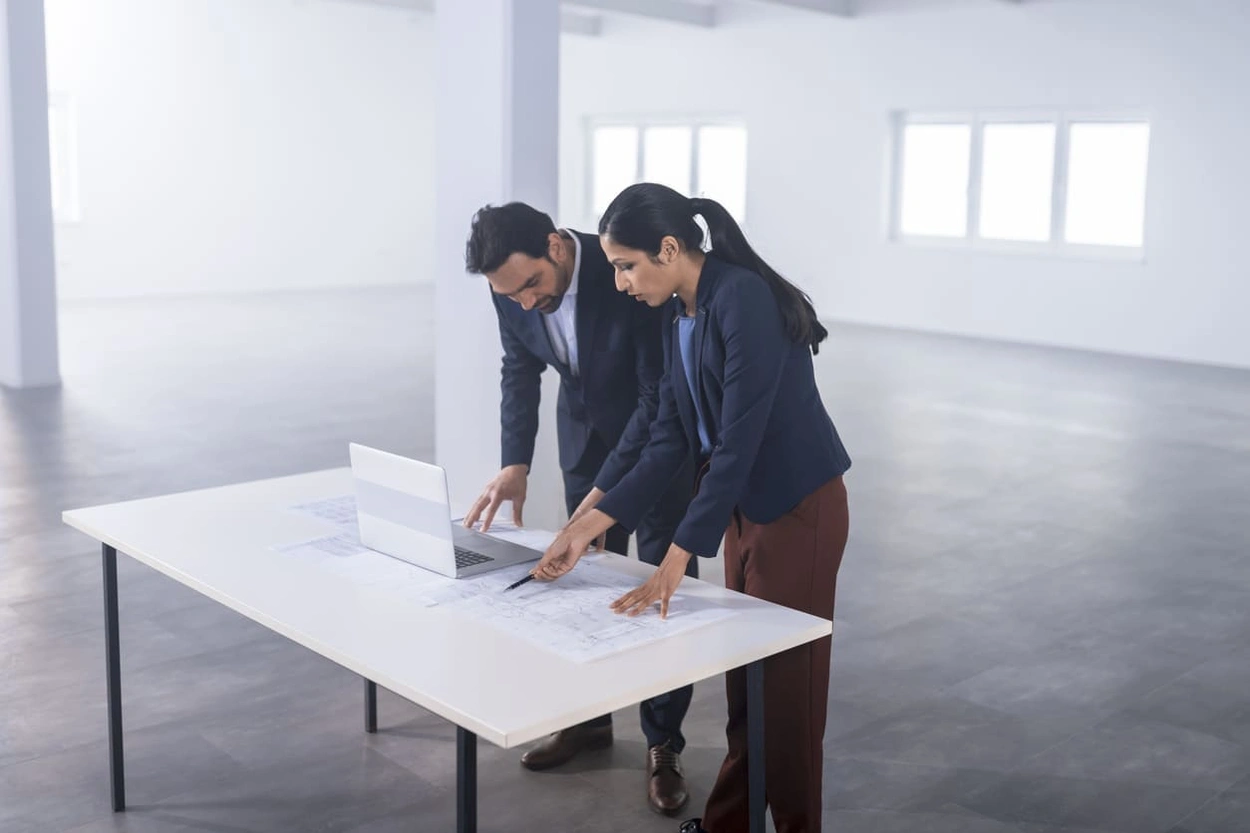 Architects spotting flaws in a blueprint caused by a paper jam in a printer plotter