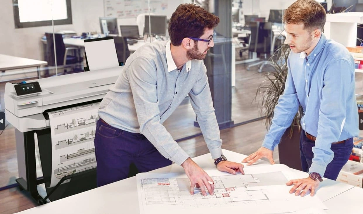 Two AEC professionals working on an A1-sized document that’s been printed by an A1 plotter printer