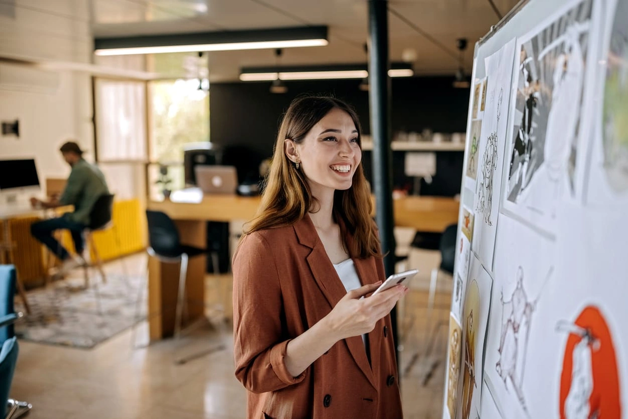 Designer reviewing printed posters in her office to determine the best quality poster printing Designer reviewing printed posters in her office to determine the best quality poster printing