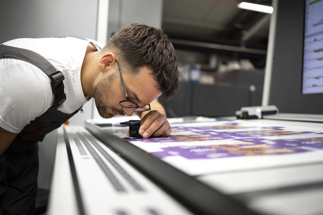 Print shop manager assessing print quality after taking steps to reduce printer ink cost Print shop manager assessing print quality after taking steps to reduce printer ink cost