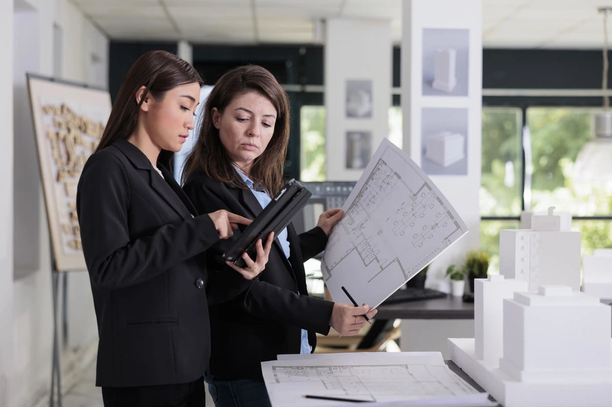 Project managers printing revisions from a tablet connected to the office plotter printer scanner