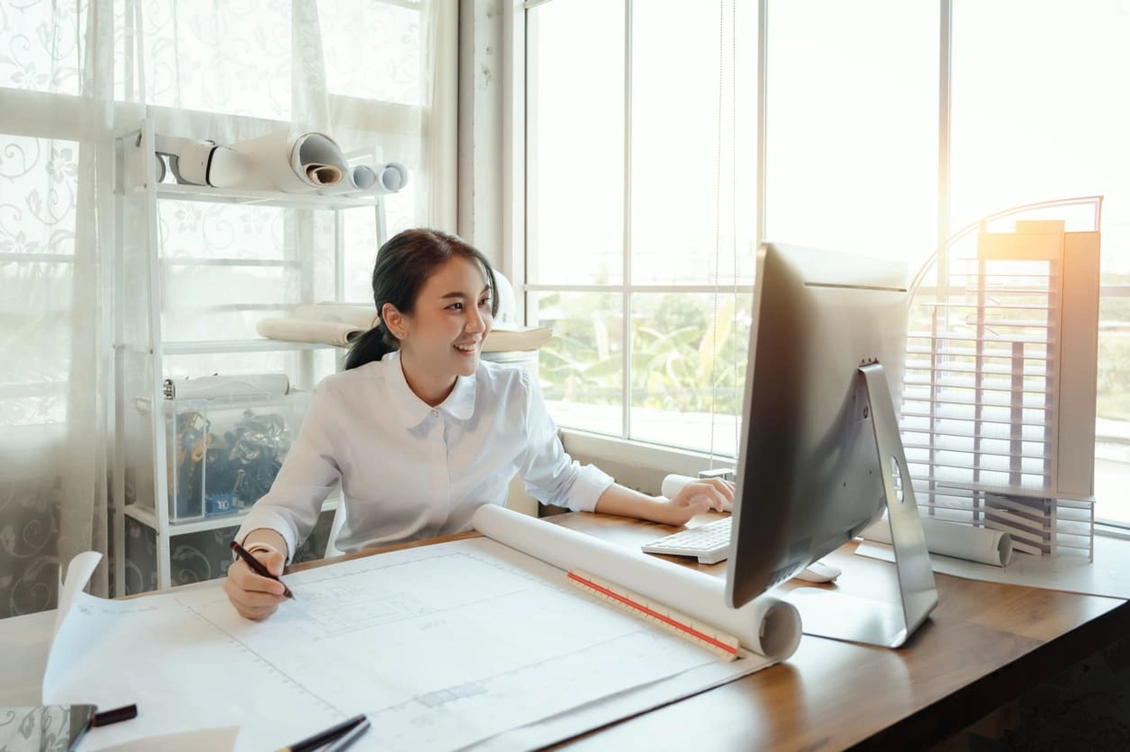 Architect using BIM software on her computer to complete BIM cost estimating tasks