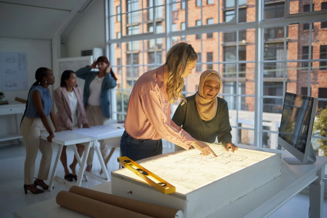 AEC coworkers reviewing the small details of a blueprint after printing it with a low-ink plotter