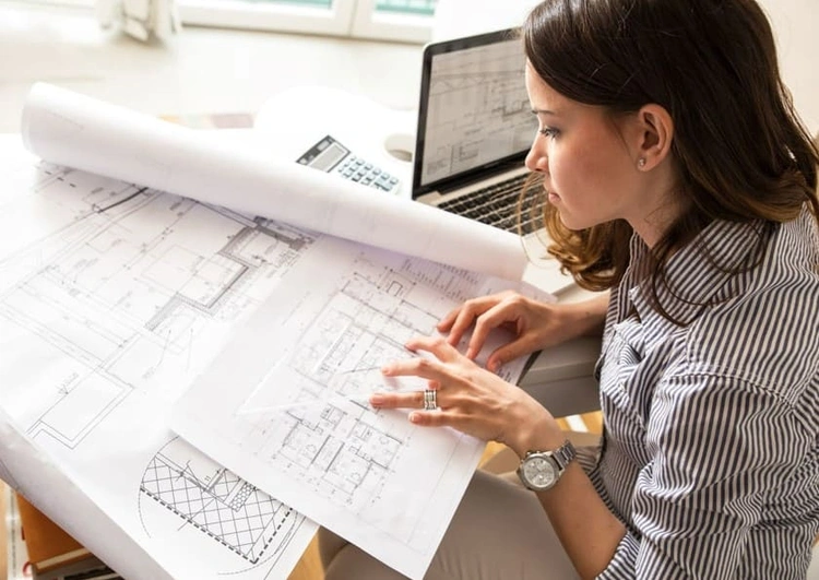 AEC professional familiarising herself with detailed blueprints and growing her architect skills