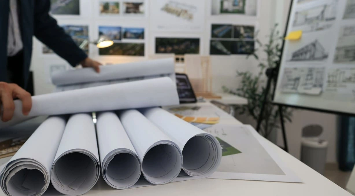 Architect reviewing large printouts and standard-sized prints Architect reviewing large printouts and standard-sized prints